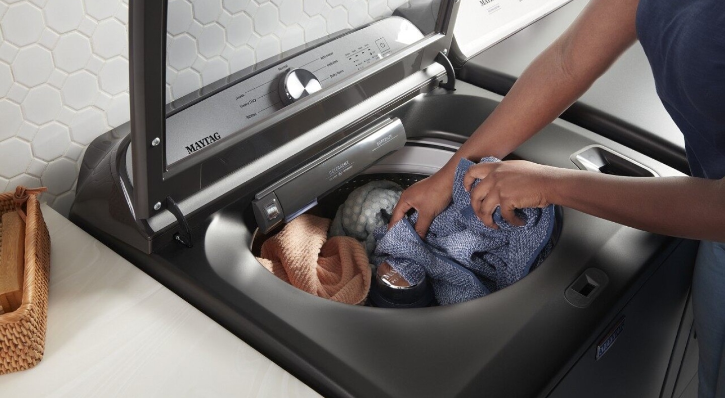 Person adding clothing to a washer