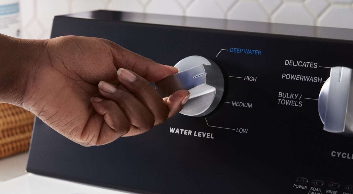 A person selecting a cycle on a washing machine A person selecting a cycle on a washing machine