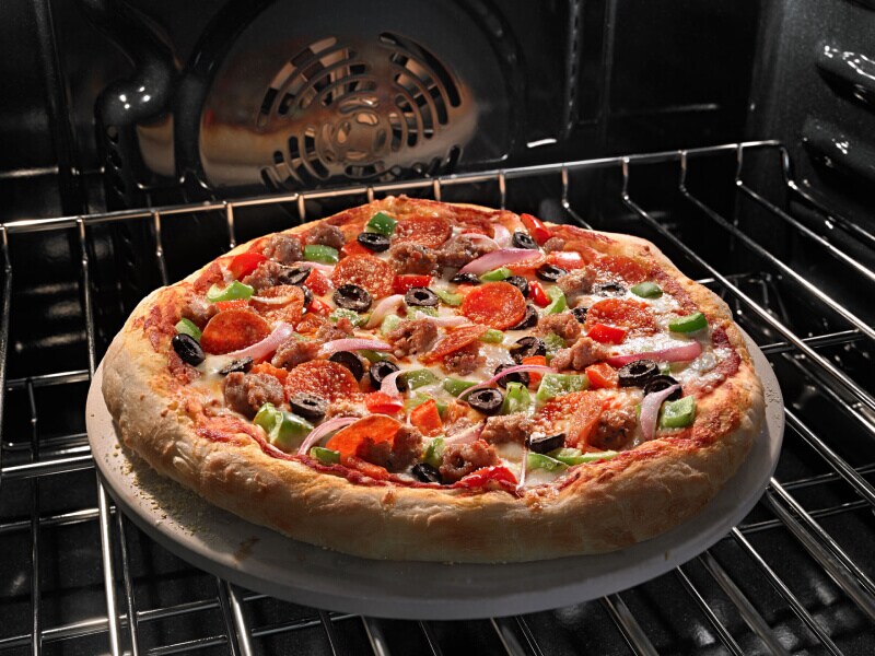 A pizza baking on an oven rack