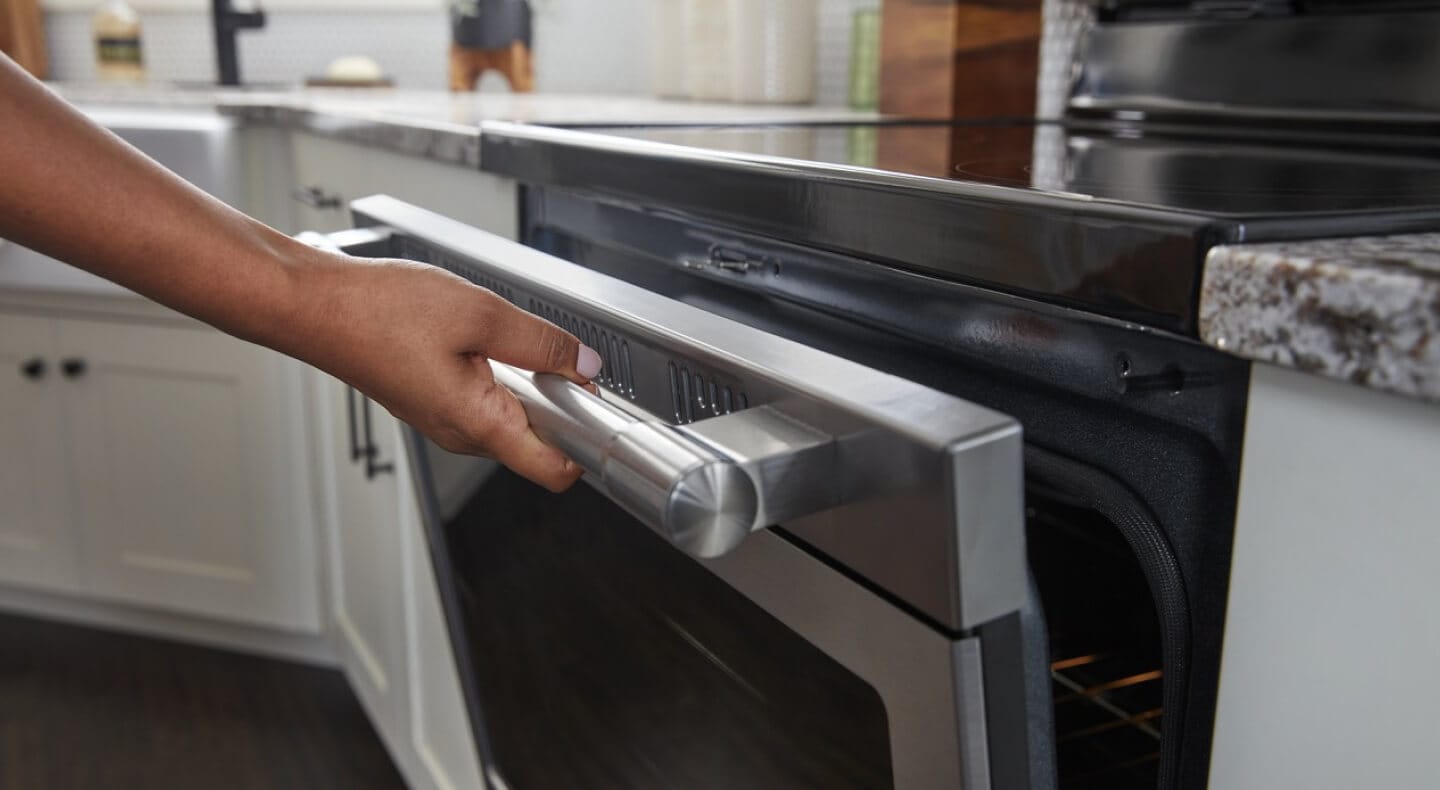 Person cracking open the door of a Maytag® electric range