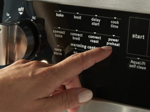 Person selecting a button on a range
