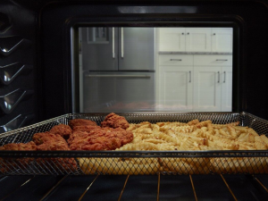 Food cooking in an oven in an air fry basket