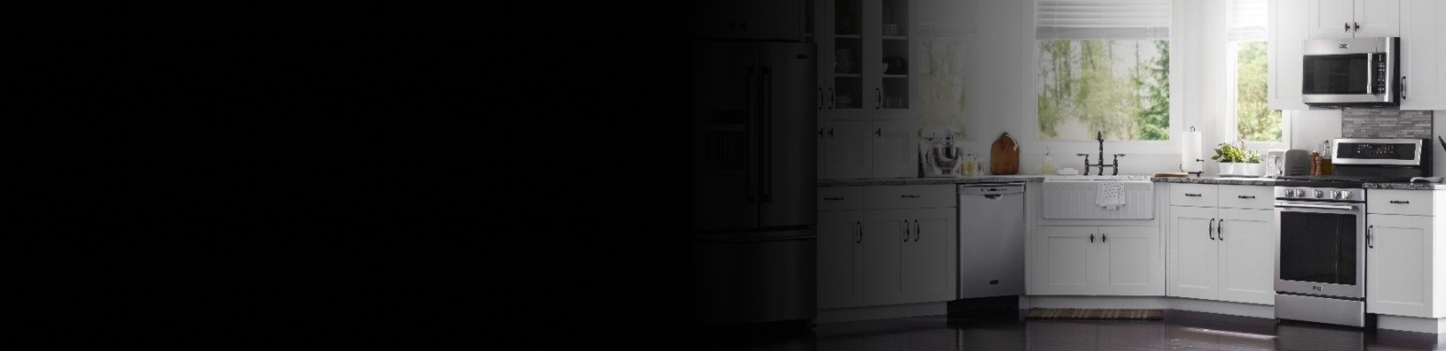 View of stainless steel appliances in a white kitchen