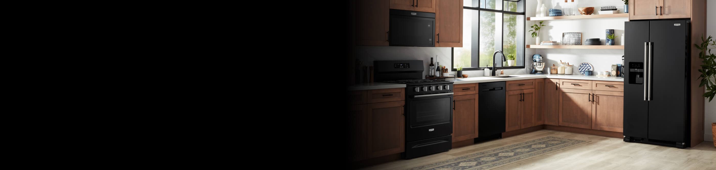 A kitchen with wood cabinets with black fixtures and black appliances
