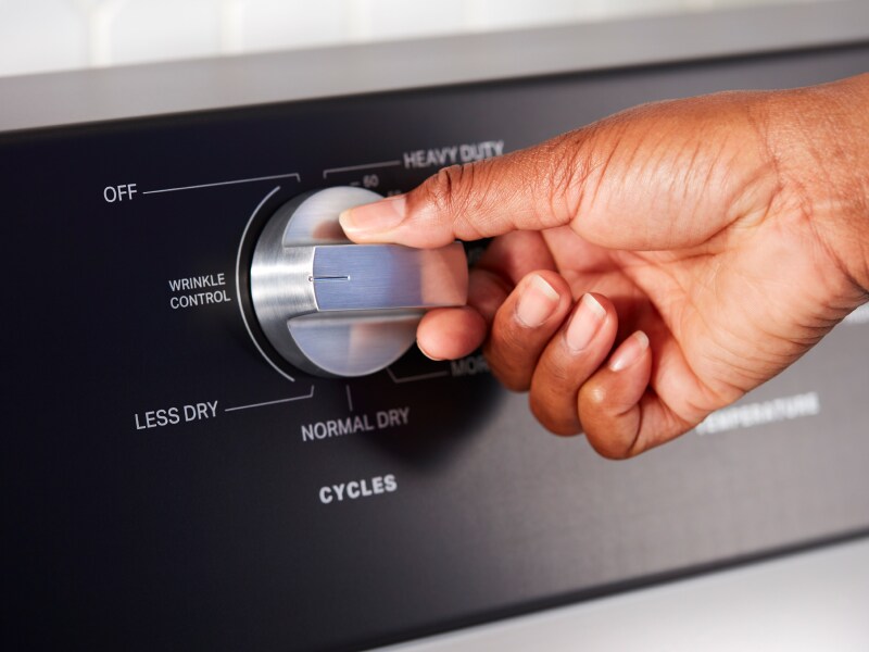 Close up of person choosing a setting on Maytag® dryer