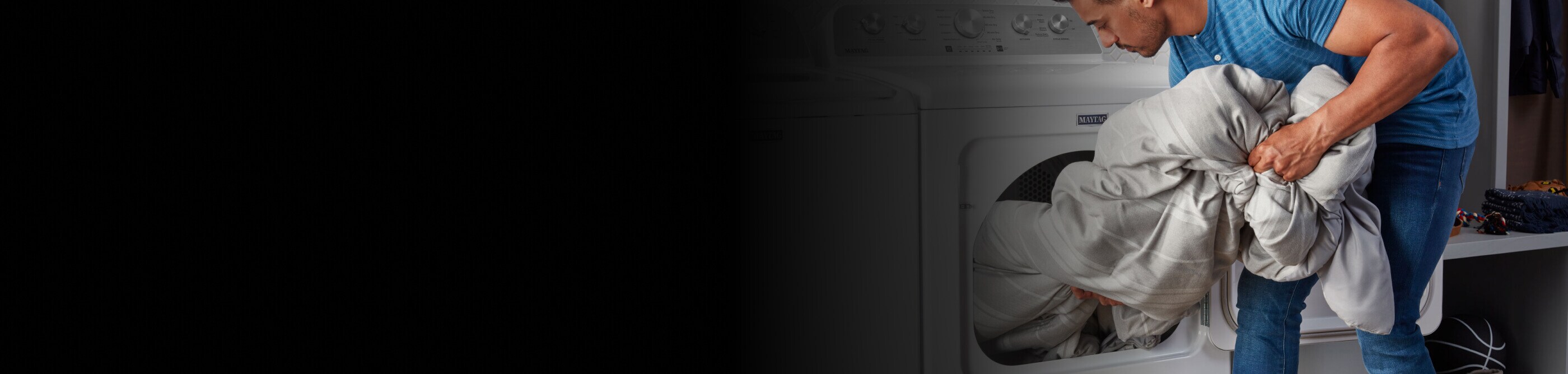 A person loading a comforter into a Maytag® front-load dryer