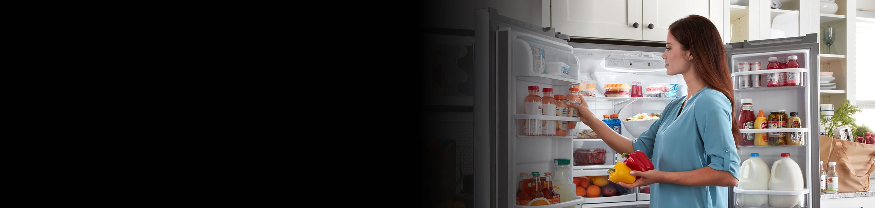 Person loading juice drinks into the door of a French door refrigerator