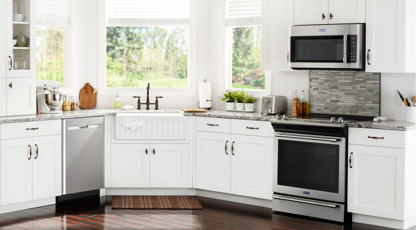 Stainless steel appliances in open kitchen with white cabinetry Stainless steel appliances in open kitchen with white cabinetry