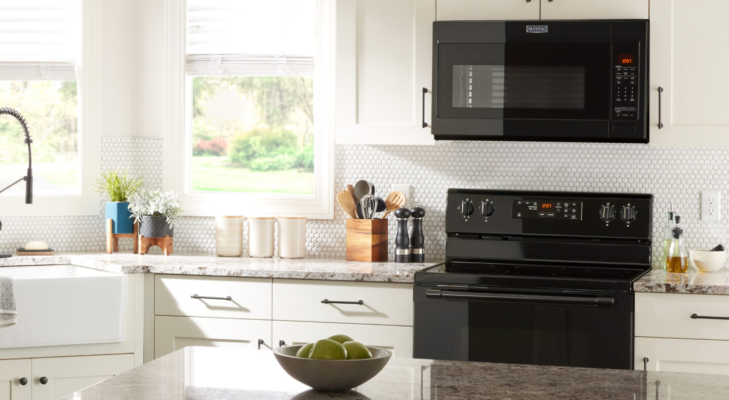 Black over-the-range microwave and range in kitchen with white cabinets Black over-the-range microwave and range in kitchen with white cabinets