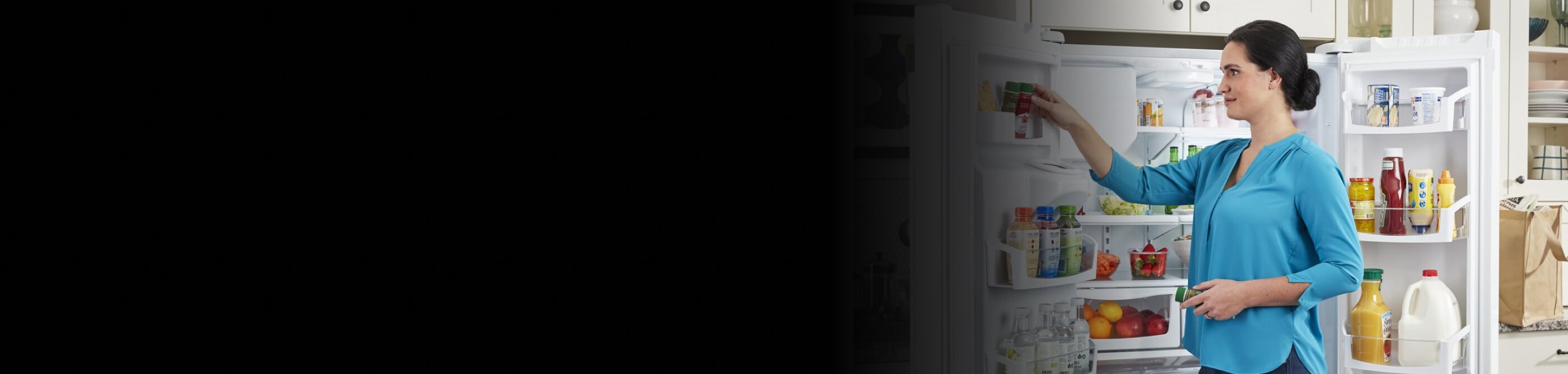 Person placing food in side door of refrigerator