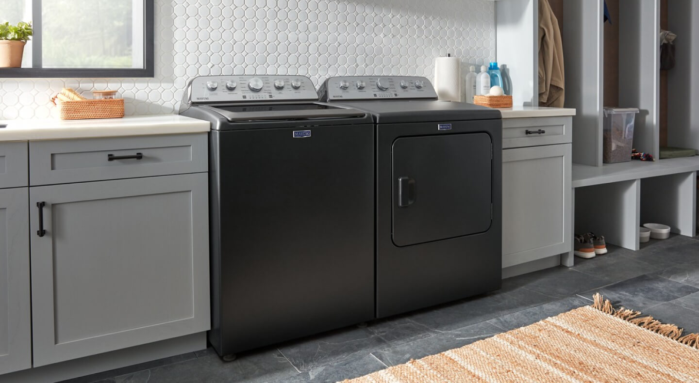 Black Maytag® top load laundry pair between gray cabinets