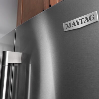 Maytag® badge on front of stainless steel refrigerator door