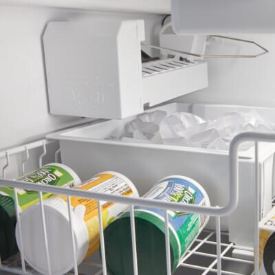 Frozen juice concentrate in front of ice maker in freezer drawer