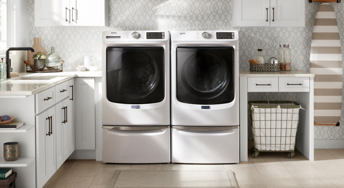 White front load Maytag® washer and dryer pair in laundry room
