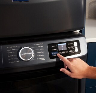 Person selecting a wash setting on a front load washer