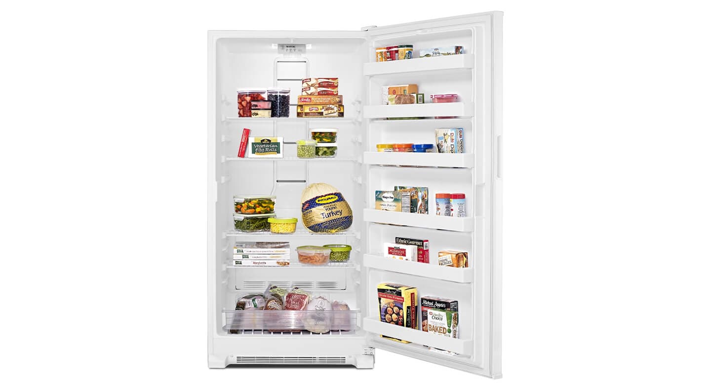 An open upright freezer with food inside