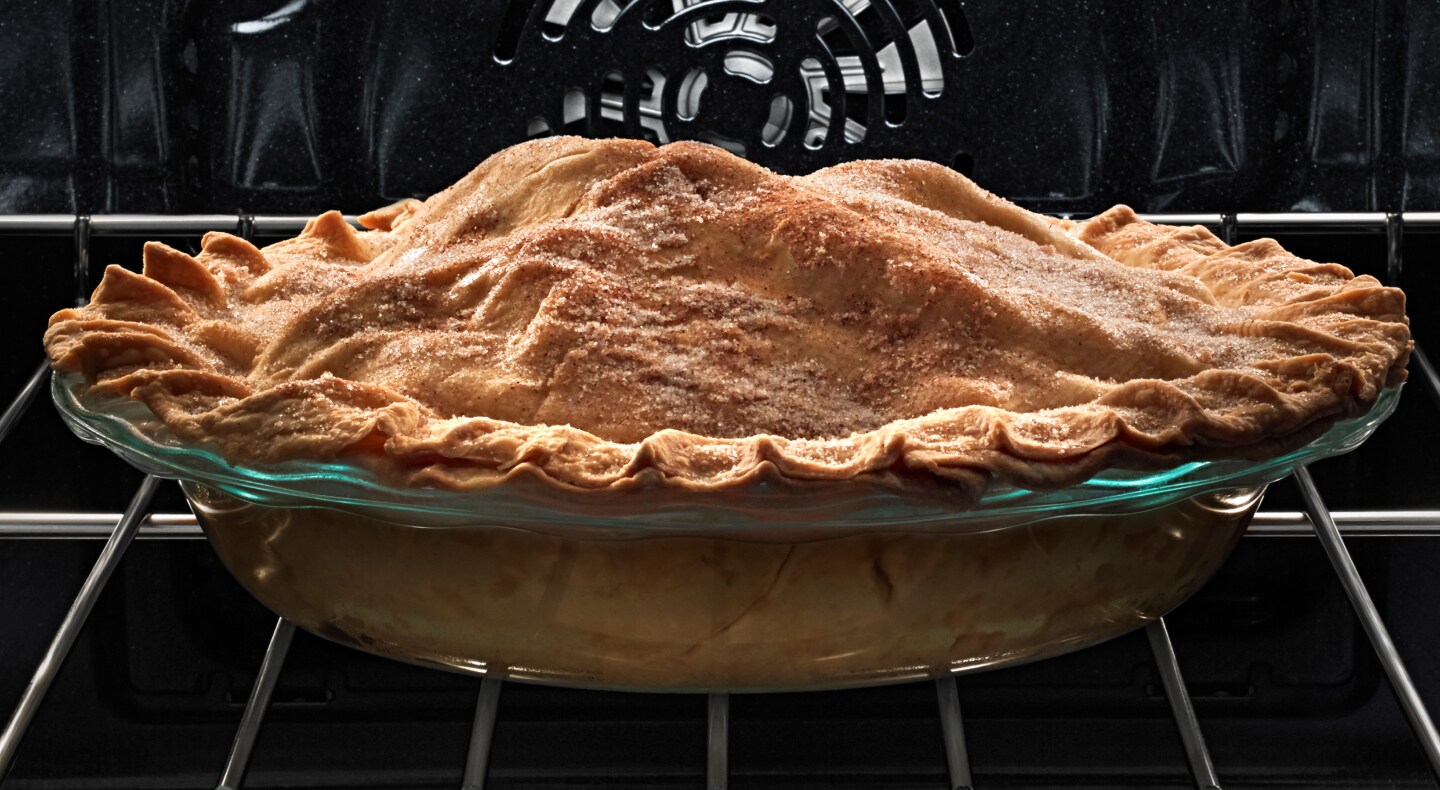 A pie with a golden crust on an oven rack A pie with a golden crust on an oven rack