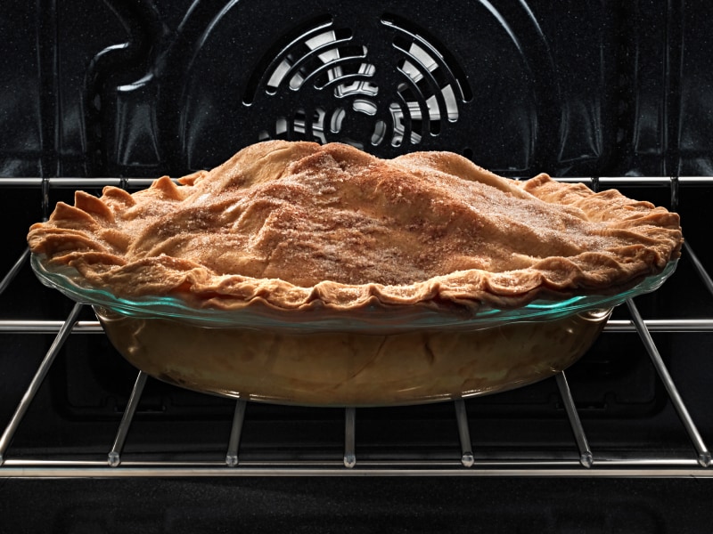 A pie with a golden crust on an oven rack A pie with a golden crust on an oven rack