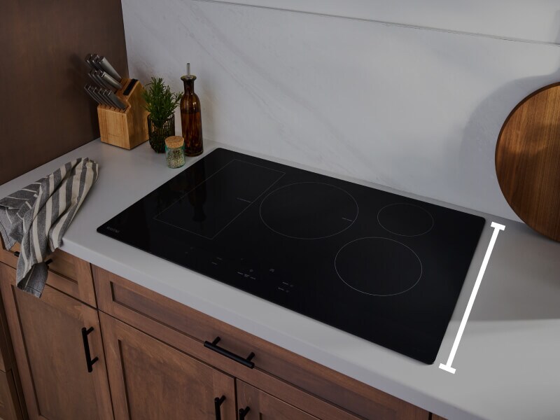 An induction cooktop with a line measuring the depth of the surface