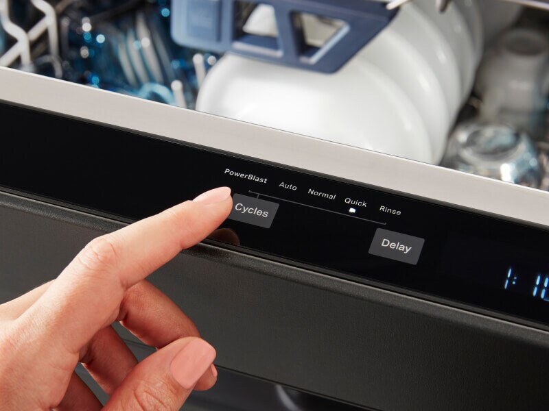 Person selecting a cycle on a dishwasher
