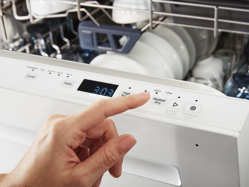 Person selecting dishwasher cycle on control panel