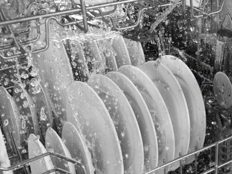 Water running over dishes in dishwasher