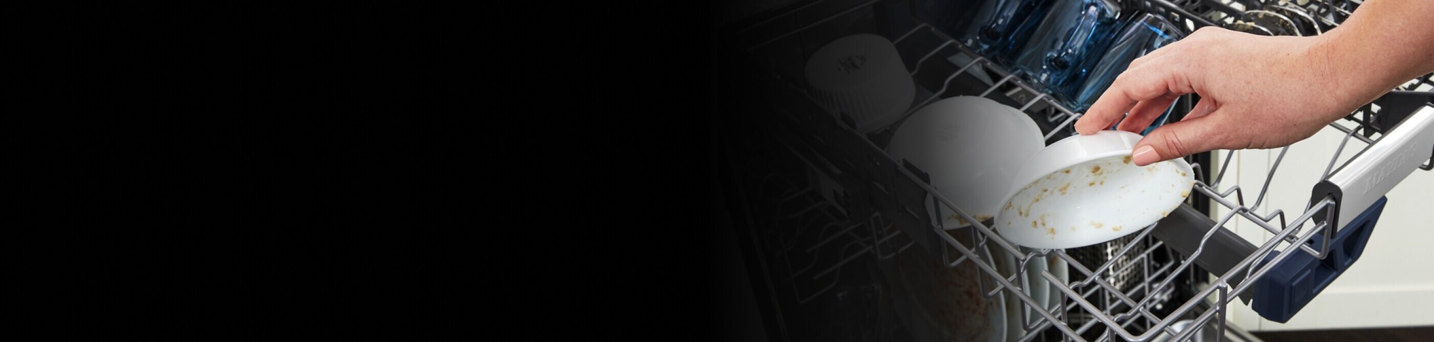 Person placing dirty dish on dishwasher rack