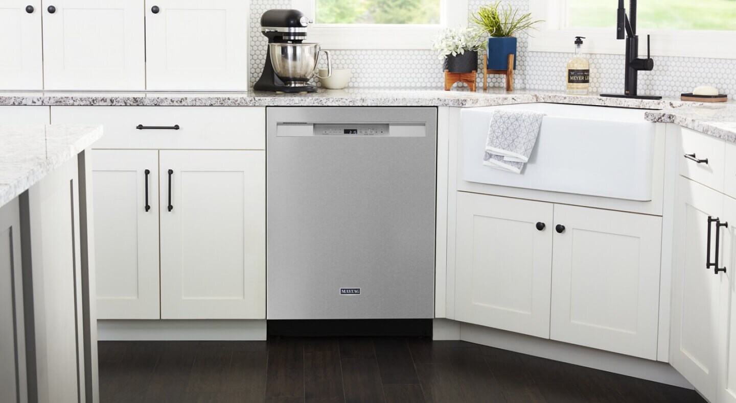 Stainless steel Maytag® dishwasher set in white cabinetry