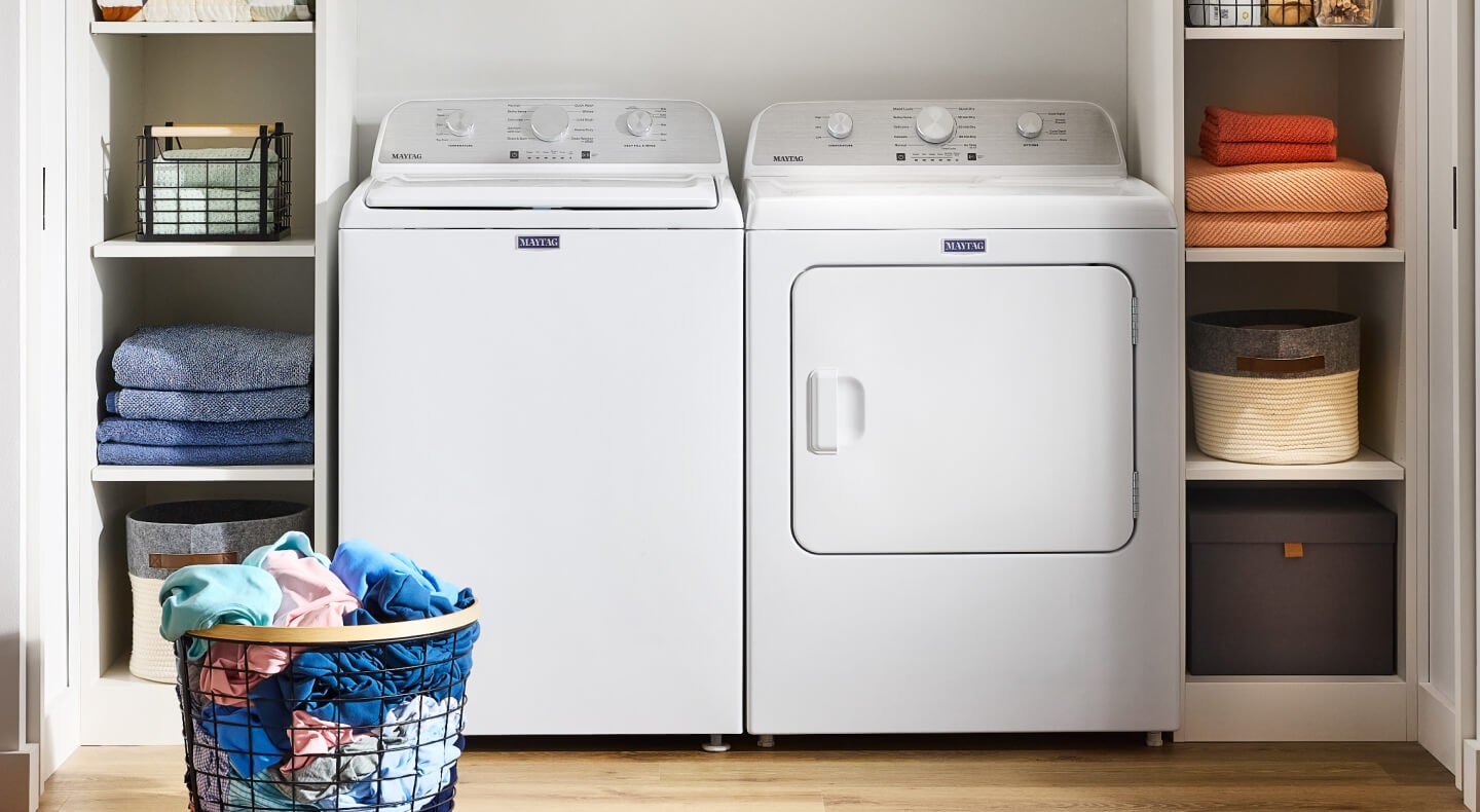 A white Maytag® top load washer and dryer in a laundry room