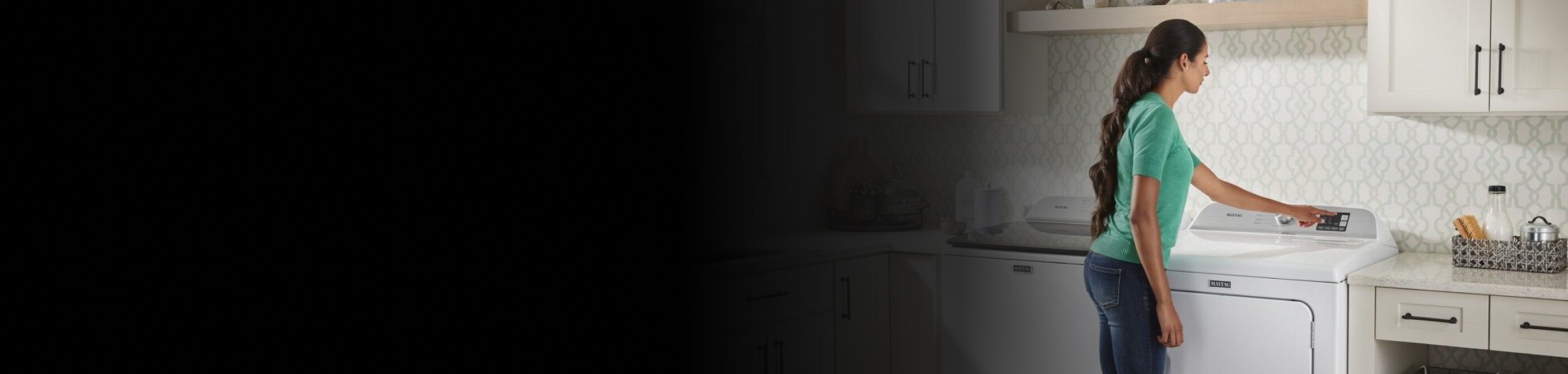 User pressing button on white front load dryer