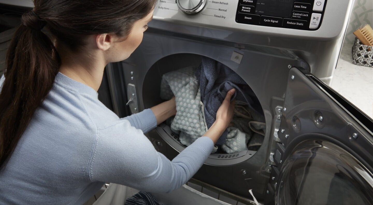 Person removing dry clothes from a front-load dryer