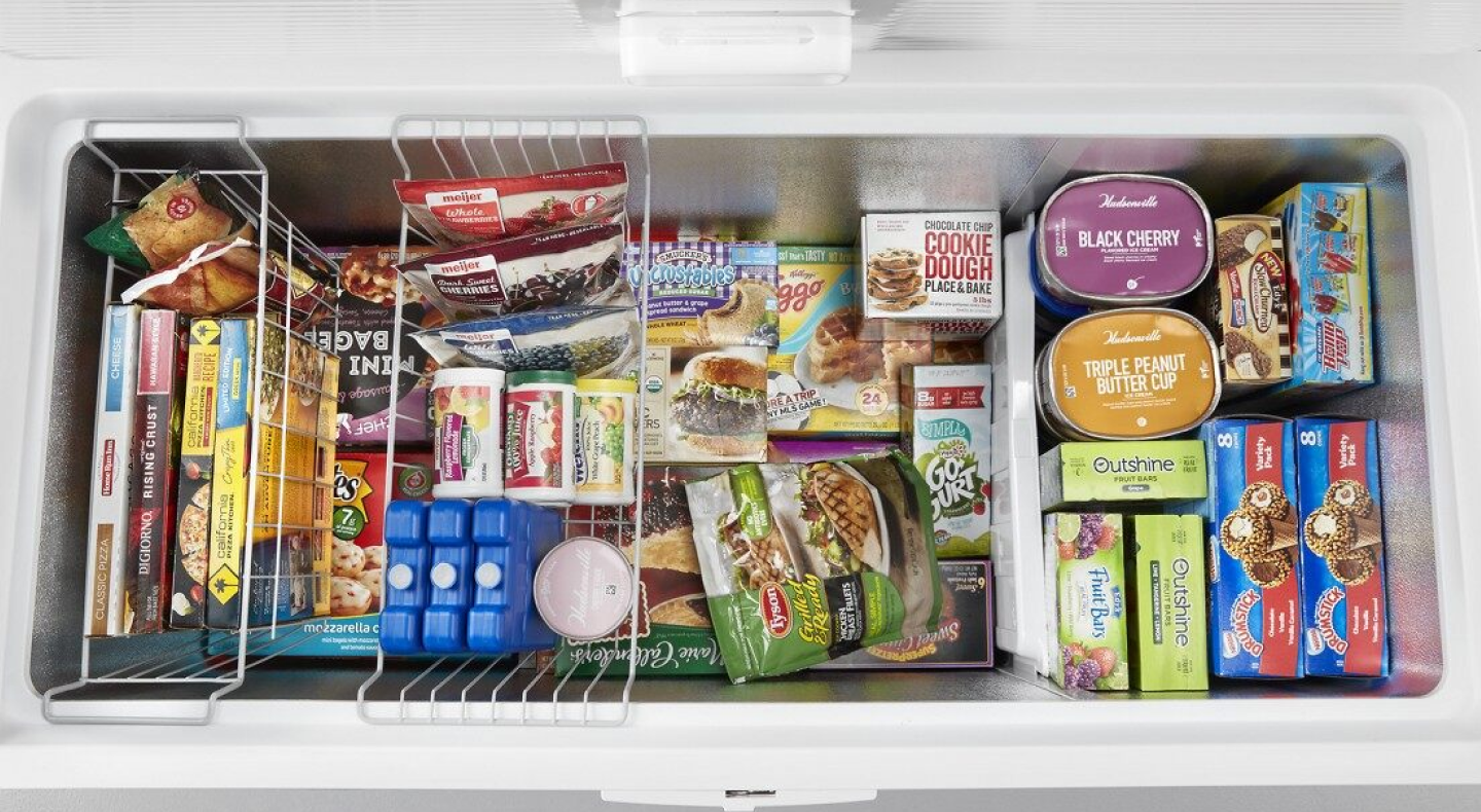 Birds-eye view of a chest freezer full of organized frozen food Birds-eye view of a chest freezer full of organized frozen food