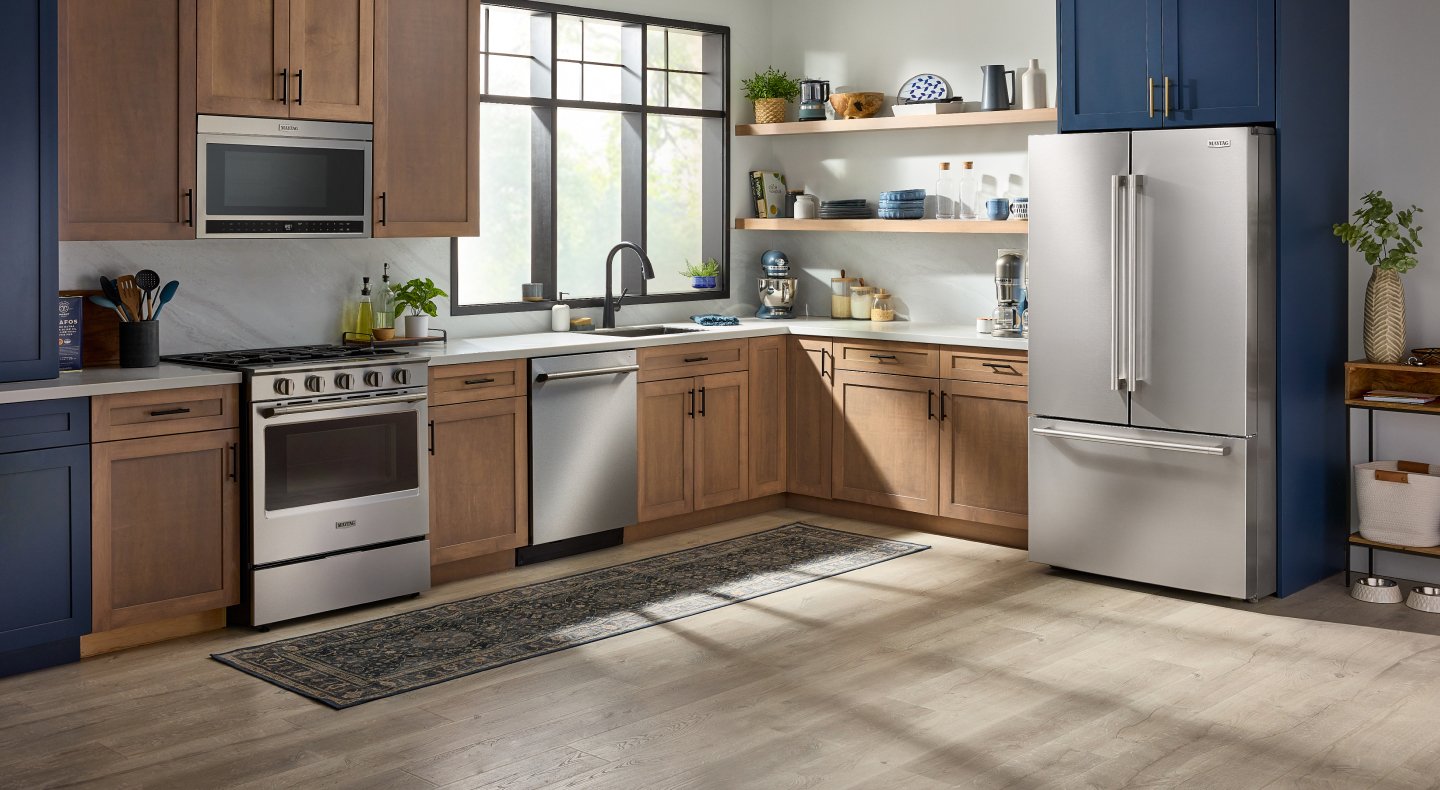 Open concept kitchen with a suite of stainless steel Maytag® appliances