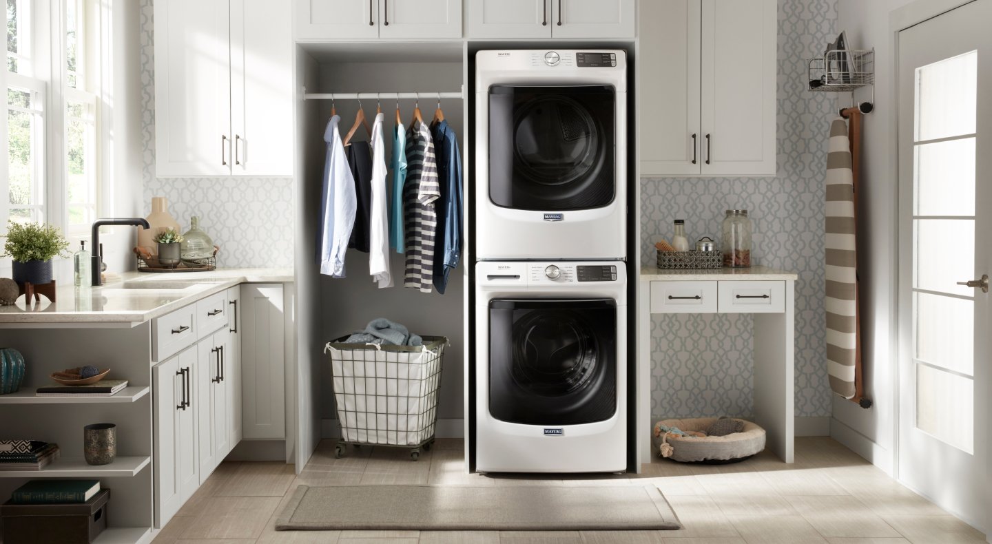 A modern, organized laundry room with a stackable washer and dryer 