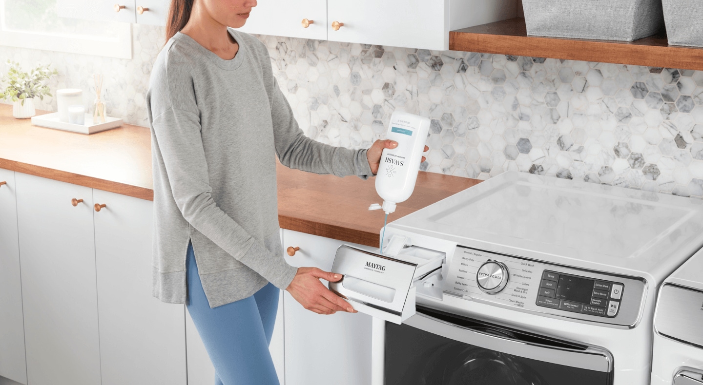 A person filling a detergent dispenser with Swash® Laundry Detergent