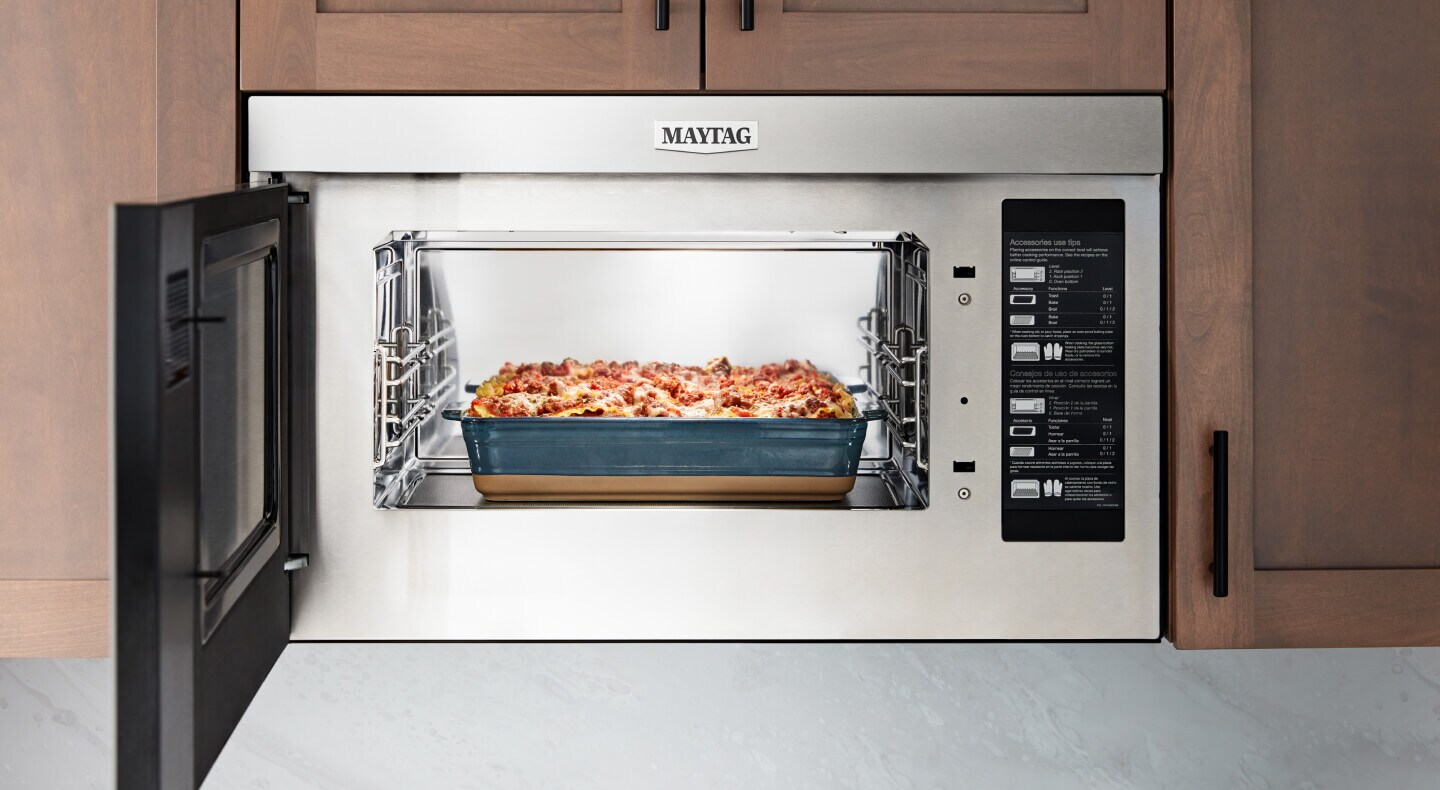 An open Maytag® Over-the-Range Microwave with food inside