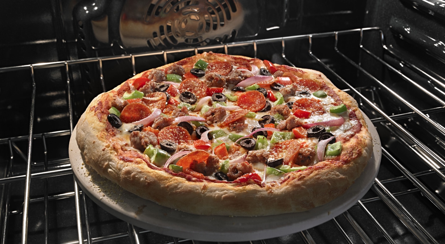 Close-up shot of pizza baking on the top sheet of an oven. Close-up shot of pizza baking on the top sheet of an oven.
