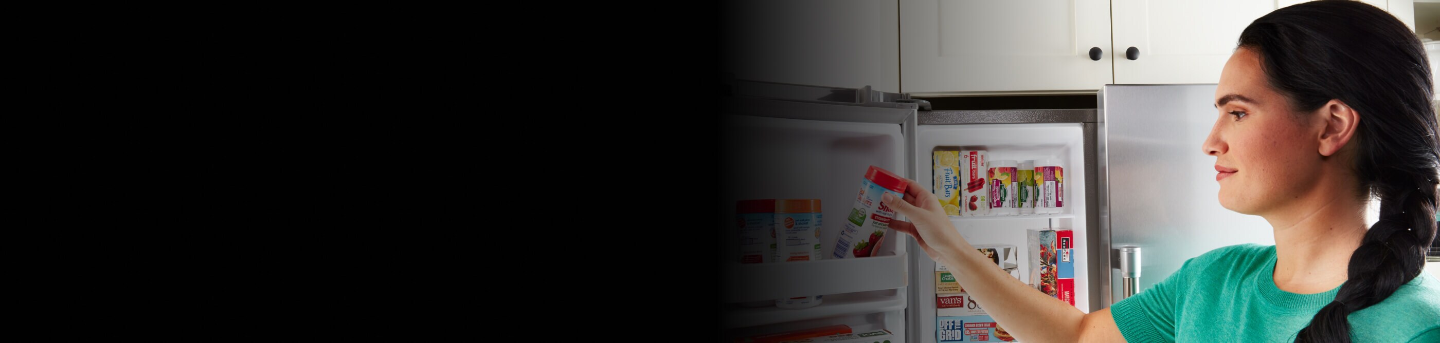 Person removing frozen food from a side-by-side fridge freezer compartment