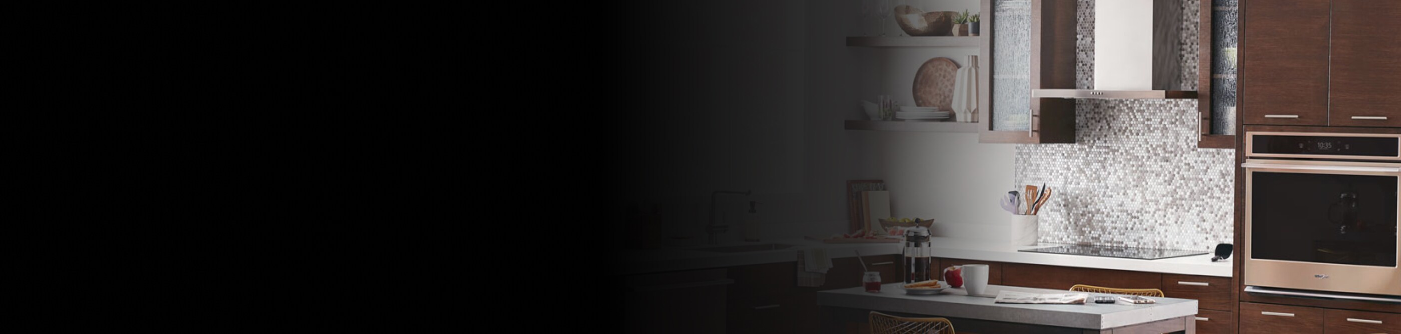 Range hood above an electric stovetop in front of a tile backsplash