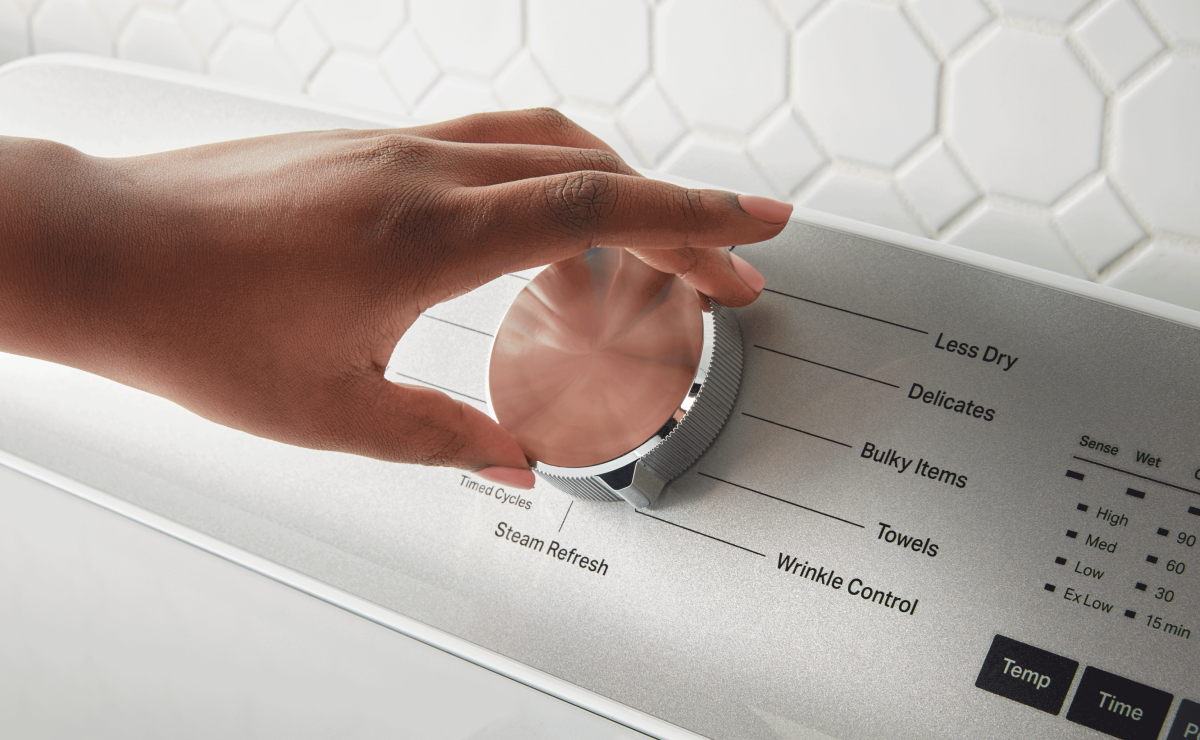 Hand making a dryer selection with a dial