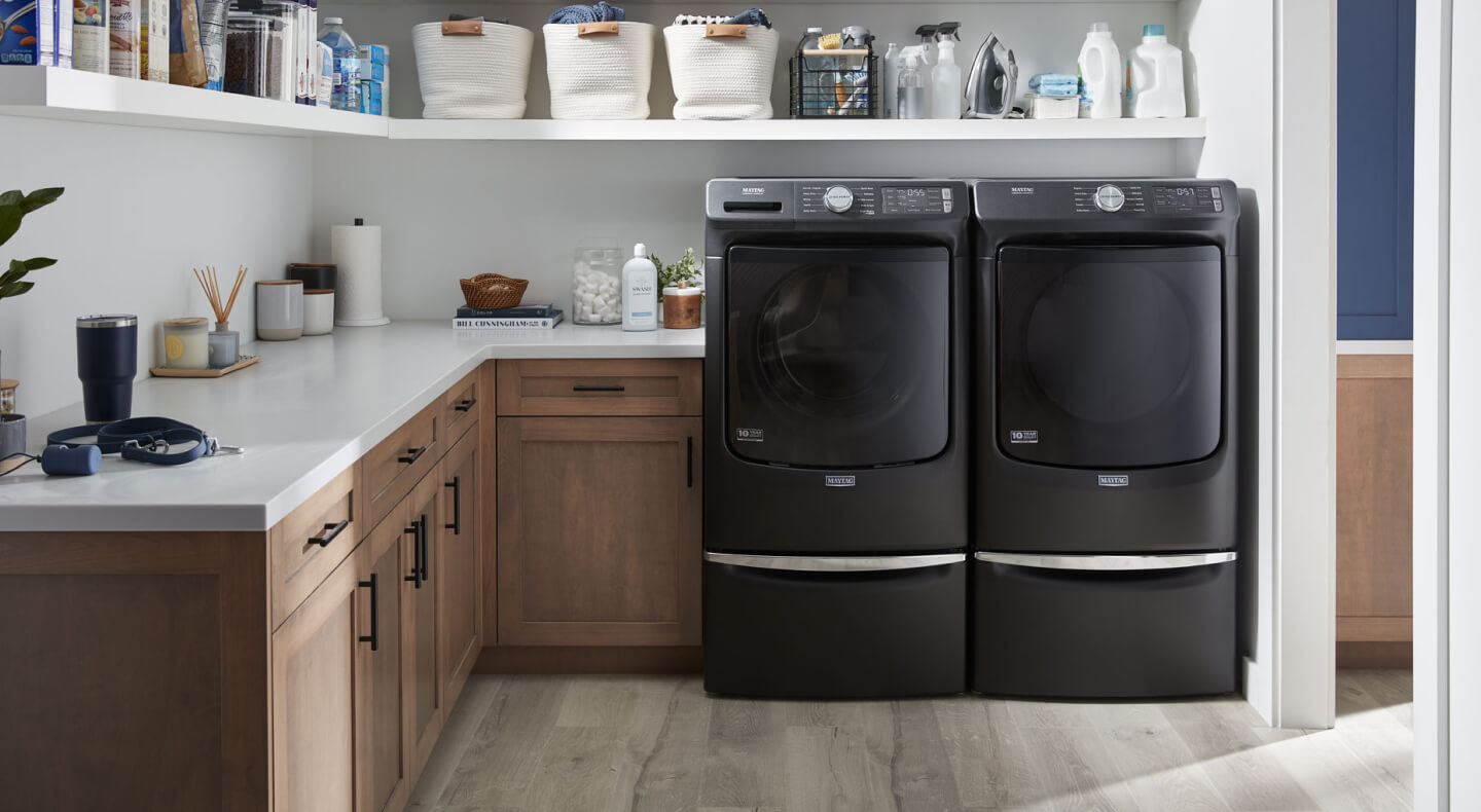 A side-by-side Maytag® washer and dryer in a modern laundry room