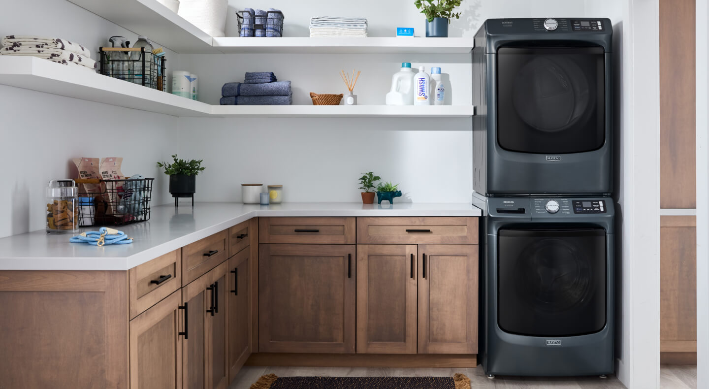 Stacked Maytag® laundry pair in Midnight Steel in an open laundry room