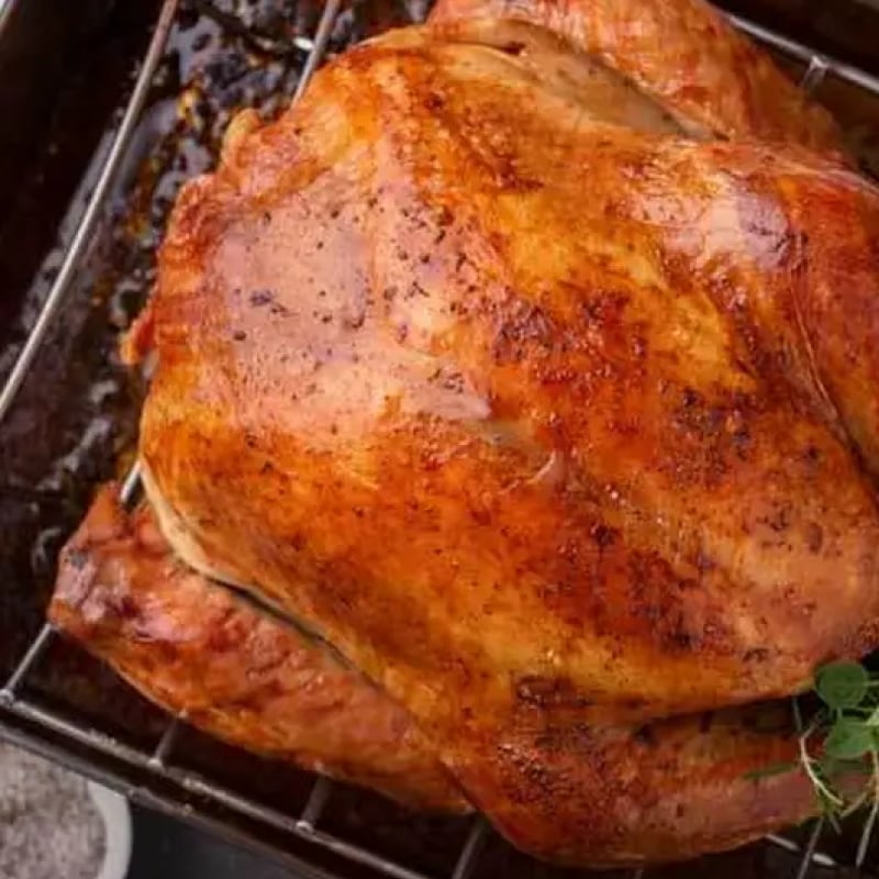 Cooking turkey in an oven rack set with its juices below