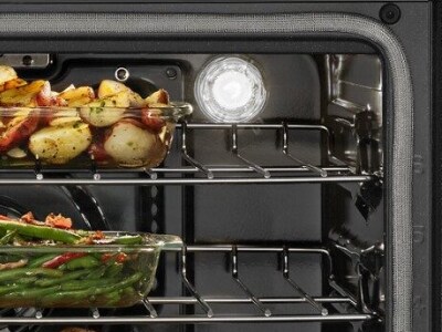 Oven light bulb illuminated with food on racks