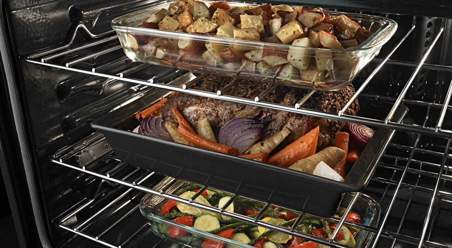 Three dishes on different racks in the oven