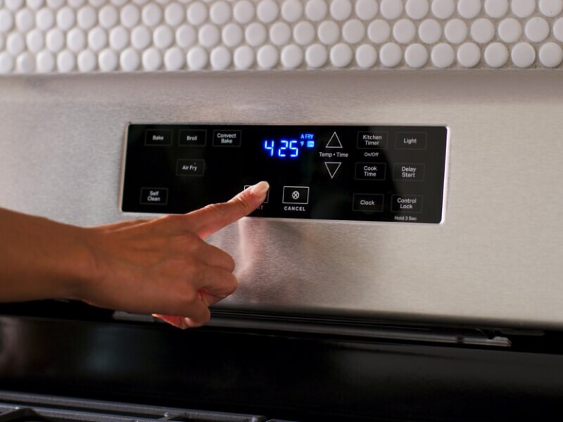 Close-up of person selecting settings on an electric control panel