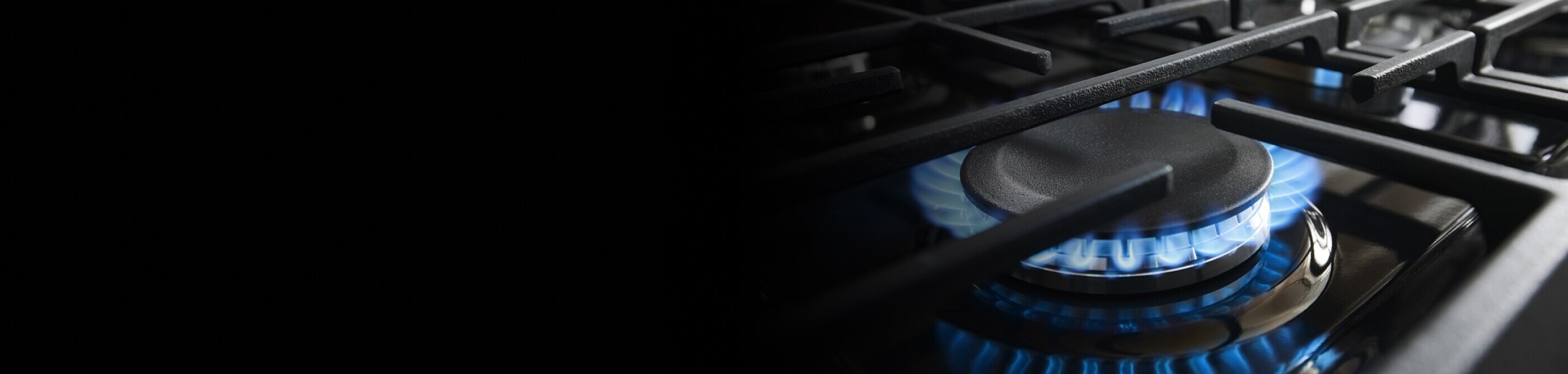 Close-up of blue flame on a gas cooktop burner