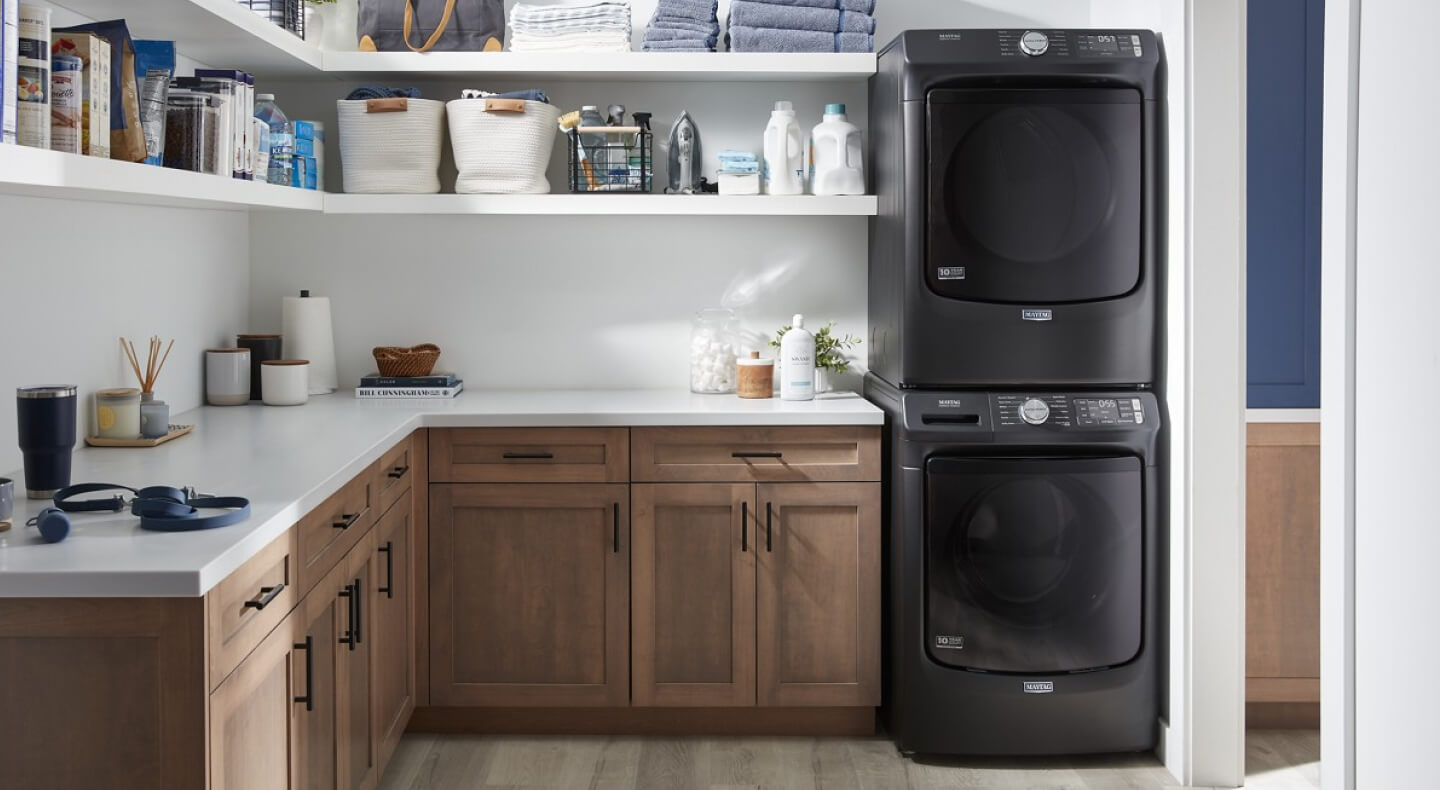 Black Maytag® stacked front load laundry pair in a laundry room