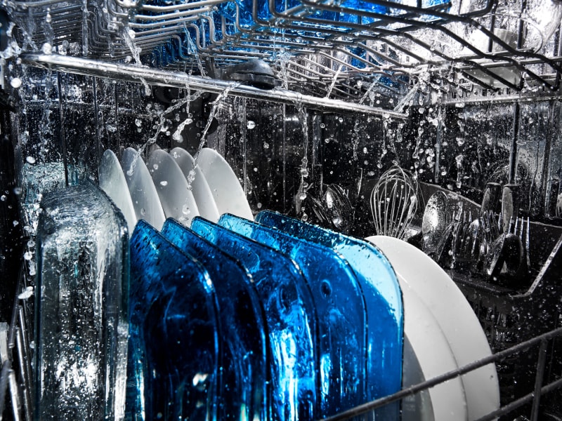 Dishes being run through a dishwasher wash cycle Dishes being run through a dishwasher wash cycle