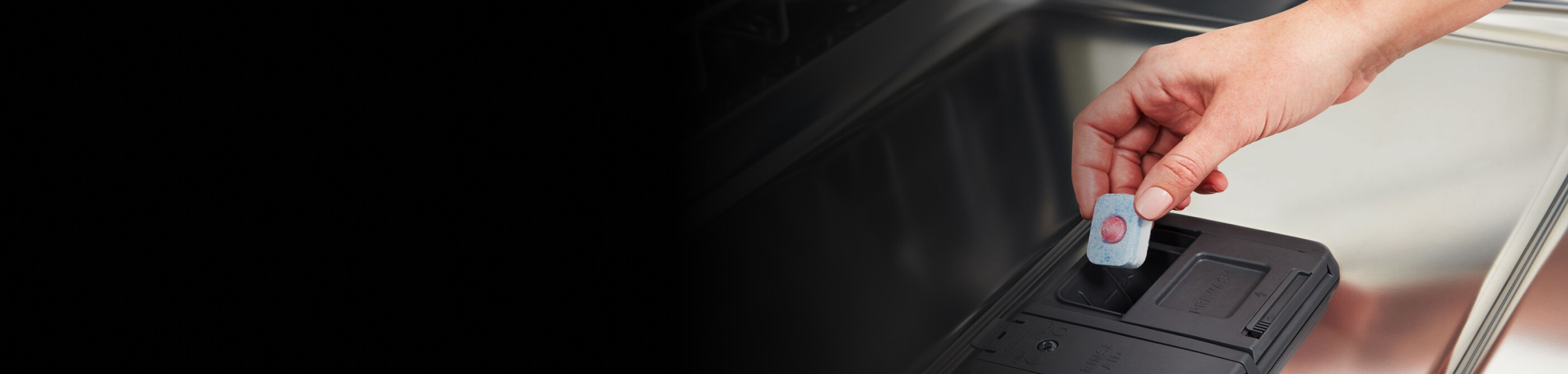 Person adding a detergent tablet to a dishwasher